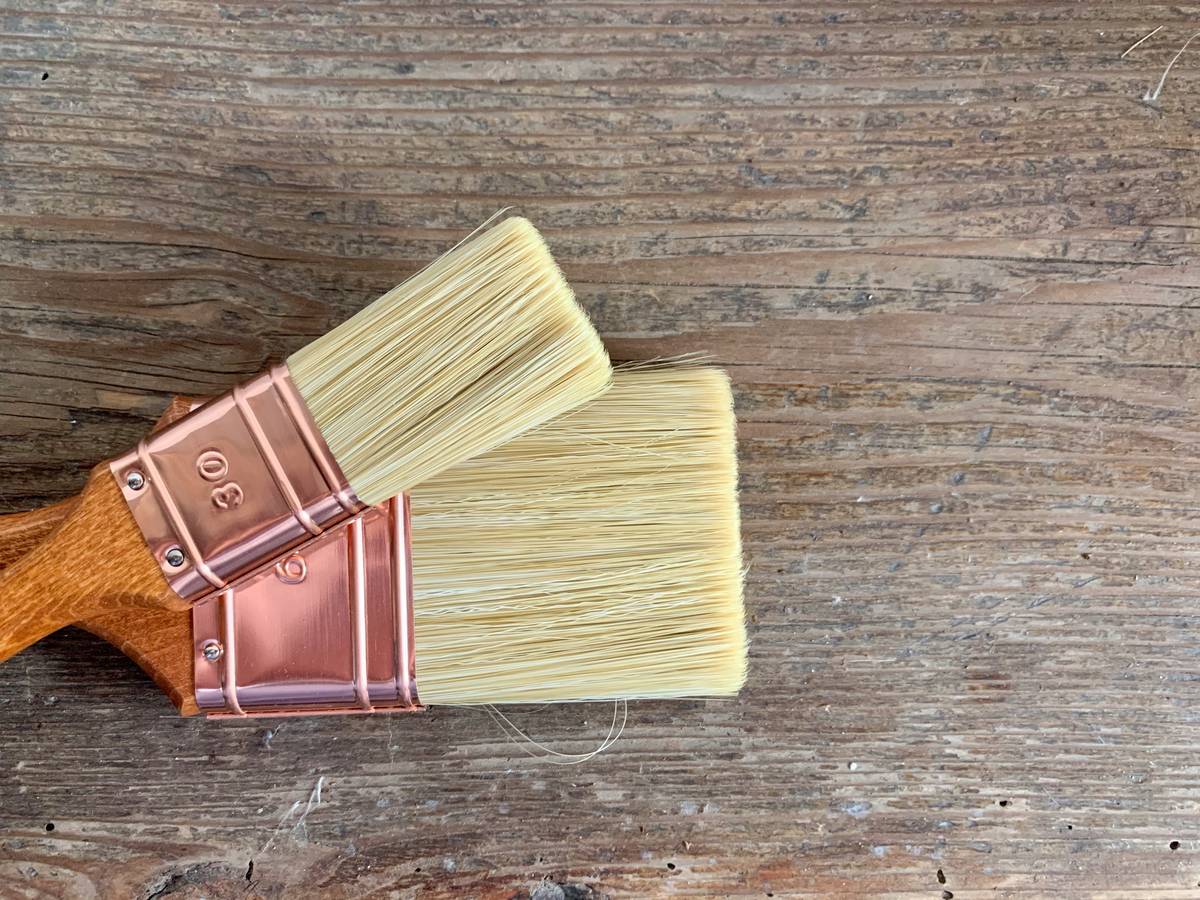 Infographic comparing ingredients in natural vs synthetic wood preservatives showing plant oils, beeswax, and mineral salts vs copper compounds and VOCs