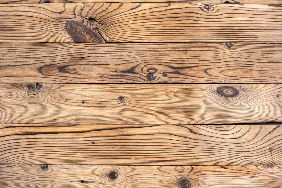 Close-up of weathered outdoor bench treated with oil based wood preservatives outdoor pine tar mixture