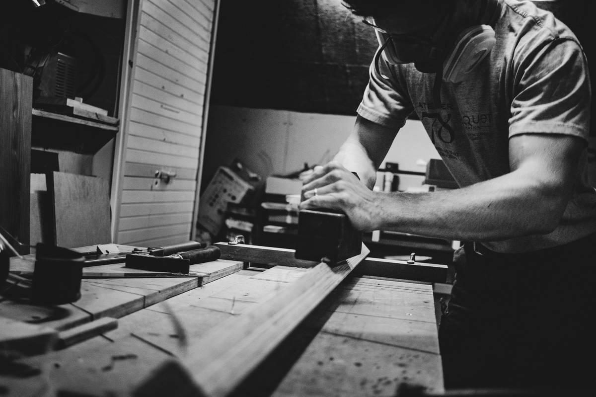 Hand applying food grade wood preservative to a wooden cutting board with a cloth